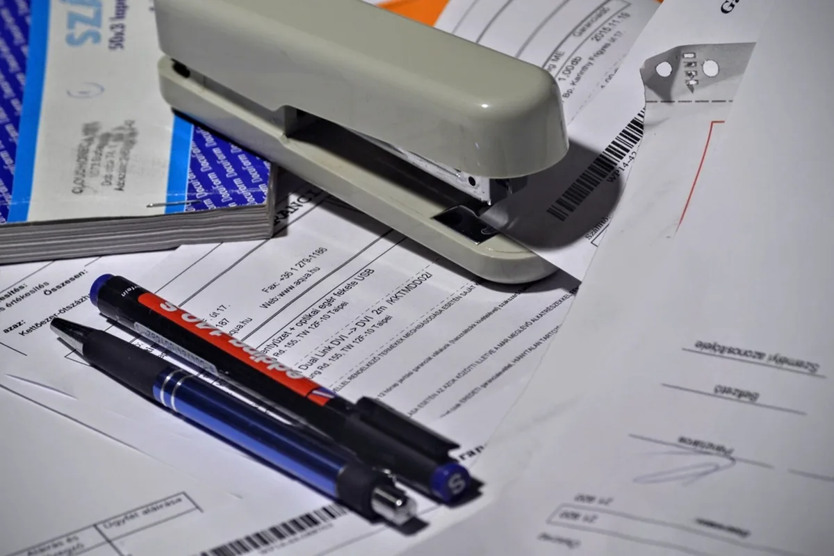 Pens and a stapler on fee paperwork for comparing assisted living costs