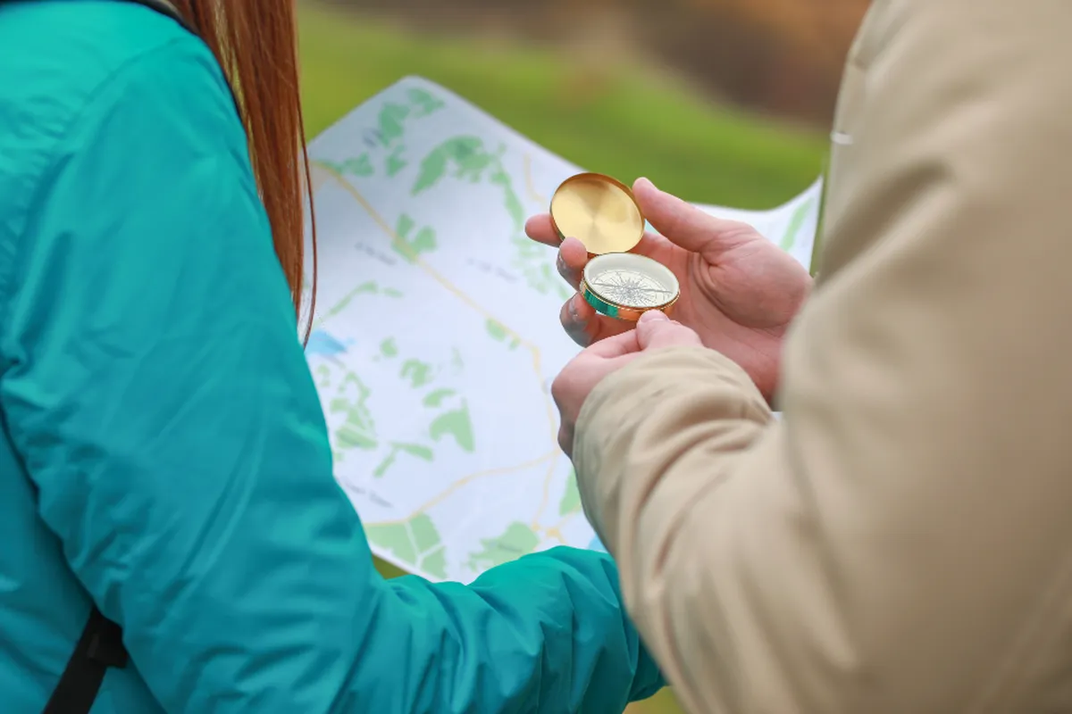 Two people checking a compass over a paper map, like a family choosing a care path